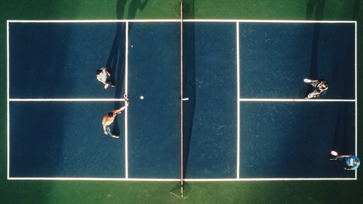 Four players in a pickleball rally, seen from above
